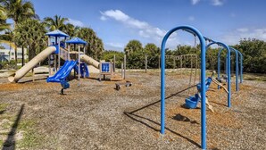 A playground with slides, climbing structures, and a swing set. - 🏖🏖 Breathtaking 1 Bedroom ~ Prime Singer Island 🏖🏖 (West Palm Beach)