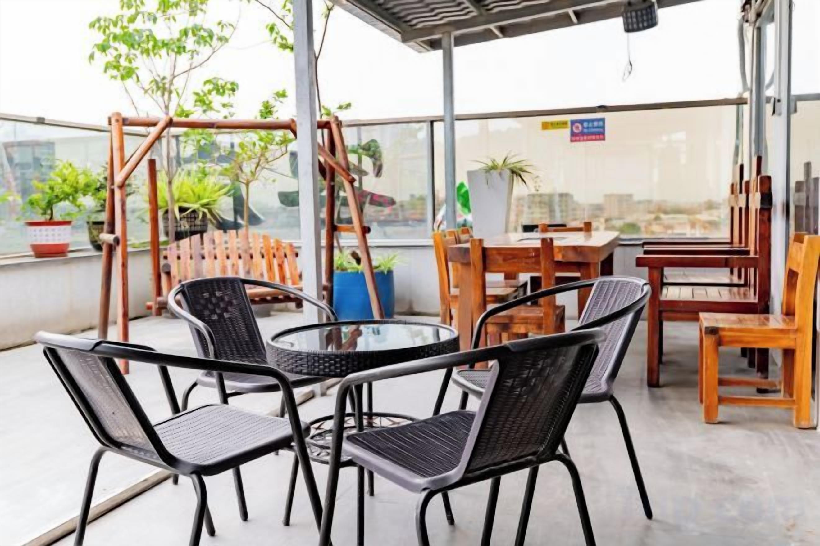 Une terrasse sur le toit, aménagée avec des meubles d’extérieur, notamment une table et des chaises, ainsi que des plantes en pot.