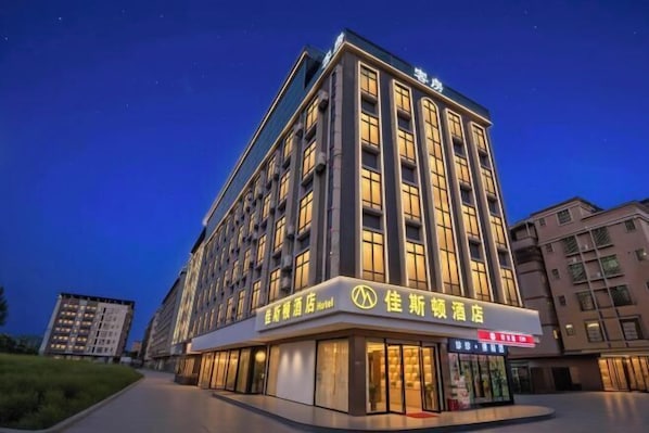 A multi-story hotel with illuminated signage, a prominent entrance, and a well-lit facade. - Huizhou galston hotel (Huizhou)