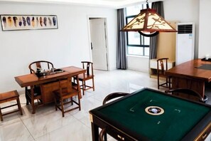 A room with a pool table, wooden chairs, a dining table, and a ceiling light fixture. - Huizhou galston hotel (Huizhou)