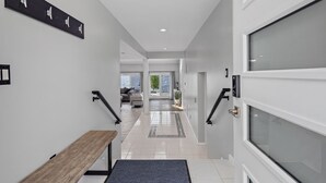 A modern hallway with a bench, a coat rack, and a view to a living area. - Candlewood Lakefront 3bd/ 2 bath house w/ 180 degree views! (Danbury)
