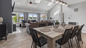 A modern dining area with a wooden table, black chairs, and woven placemats. - Candlewood Lakefront 3bd/ 2 bath house w/ 180 degree views! (Danbury)