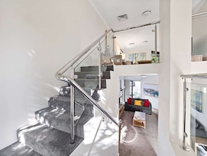 A modern interior with a glass staircase leading to a living area. - Surfside 1—An Unforgettable Yallingup Experience (Yallingup)