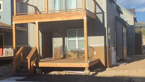 En toetages træbygning med balkon, overdækket veranda og en indhegnet have.