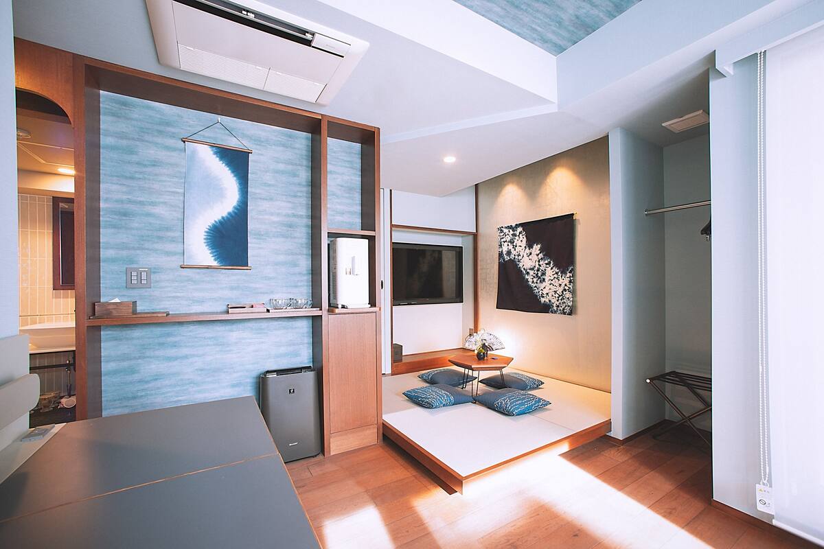 Quarto de hotel moderno com cama, mesa de cabeceira, obra de arte e ar condicionado instalado.