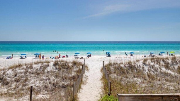 A beach with a sandy path leading to the water, surrounded by dunes. - Koko Palms Home with Pool, Carriage House & Cart (Destin)