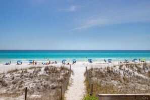 A beach with a sandy path leading to the water, surrounded by dunes. - Koko Palms Home with Pool, Carriage House & Cart (Destin)