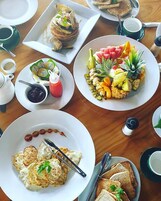 Un desayuno con diversas opciones de comida, como panqueques, fruta y huevos.