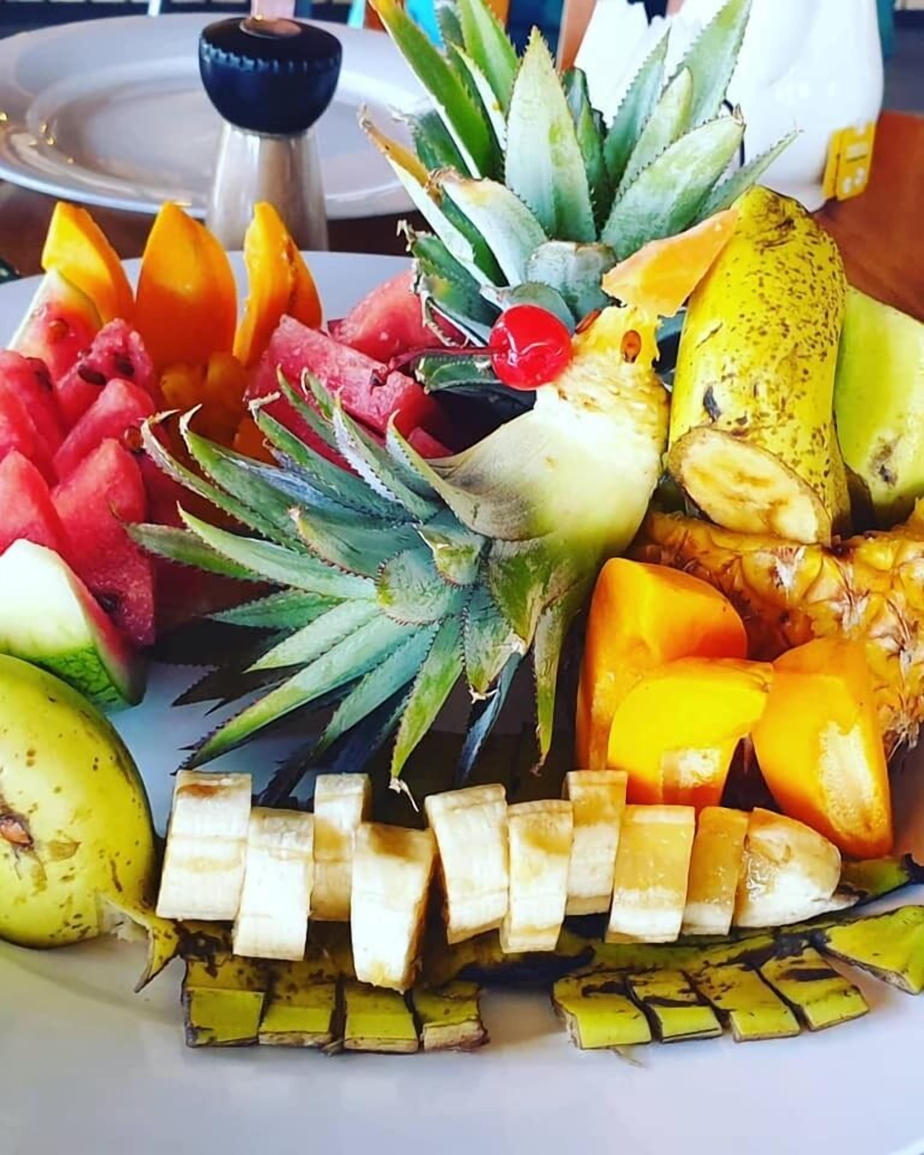 Una bandeja de frutas con piña, mango, sandía y rodajas de plátano.