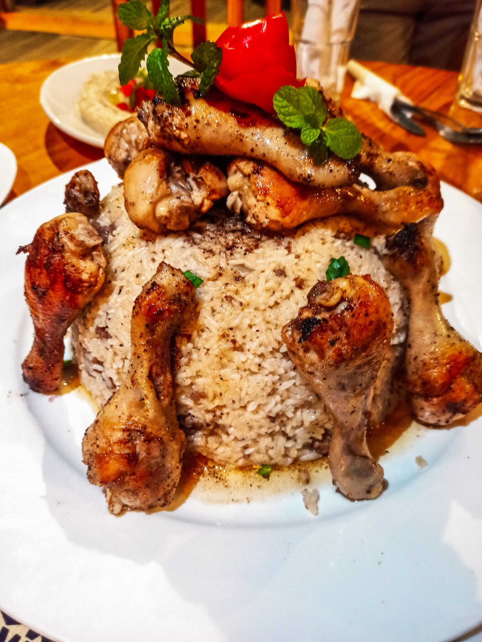 Un plato de comida con arroz y muslos de pollo.