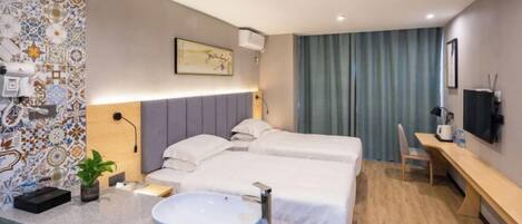 A modern hotel room with a large bed, a desk, a bathroom with a sink, and a decorative wall.
