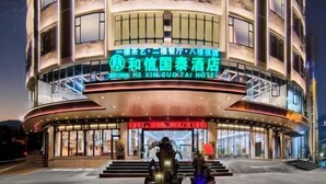 A hotel with a curved facade, multiple floors, and a prominent entrance with a fountain. - Danzhou Guanlan Shangpin International Hotel (Danzhou)