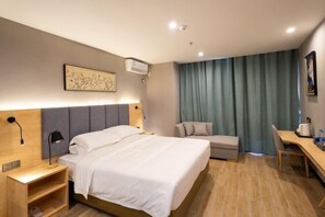 A modern hotel room with a large bed, bedside tables, a desk, and a chair. - Danzhou Guanlan Shangpin International Hotel (Danzhou)