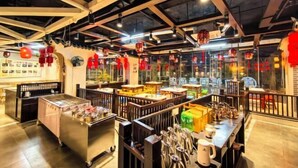 A restaurant interior with tables, chairs, and a counter with various items. - Danzhou Guanlan Shangpin International Hotel (Danzhou)