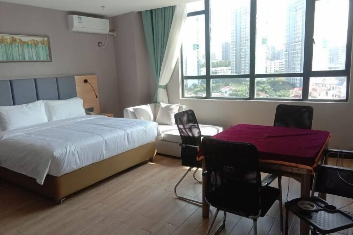 Una habitación de hotel con una cama, un escritorio con una silla y una ventana con vista a la ciudad.