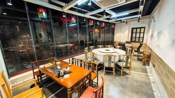 Un restaurante con mesas y sillas redondas, ventanas amplias y un diseño de interiores moderno.