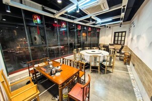 Un restaurante con mesas y sillas redondas, ventanas amplias y un diseño de interiores moderno.