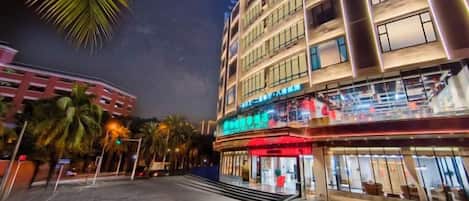 Un hotel de varios pisos con un restaurante en la planta baja y una escalera visible que conduce a la entrada.
