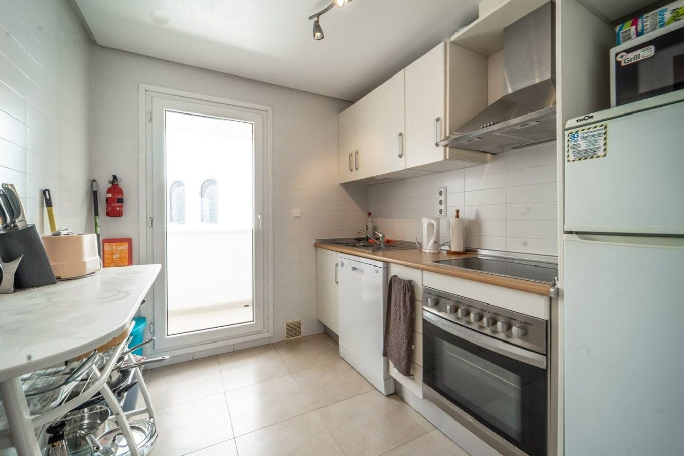 Une cuisine équipée d’une cuisinière, d’un four, d’un évier et d’une fenêtre.