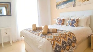 A bedroom with a bed, a bedside table, a window with curtains, and a painting on the wall. - East facing apartment with golf views - AO311LT (LTGR Roldán)