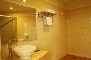 Un baño con un espejo grande, un lavabo y un perchero para toallas.