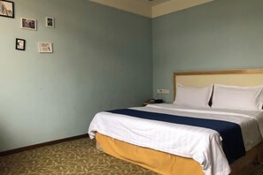Una habitación de hotel con una cama, una mesita de noche y un teléfono instalado en la pared.