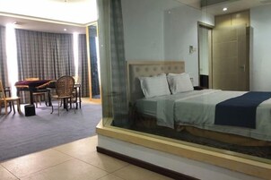 Quarto de hotel com cama, escrivaninha e cadeira.