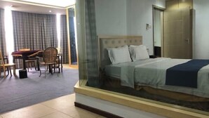 A hotel room with a bed, a desk, and a chair. - Xiaolan Yinhe Business Hotel (Zhongshan)