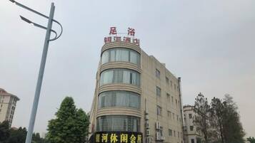 Un edificio de varios pisos con letreros de un hotel y un centro de recreación.