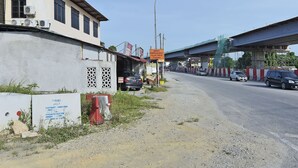 A building with a signboard, a street with cars, and a bridge in the background. - OYO 90535 Wakaf Bharu Inn (Tumpat)