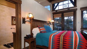 A bedroom with a bed, bedside lamps, a wooden headboard, and a view through a window. - The Gray Fox! Luxury, Hot tub, Sauna, Ski in/out (Mt. Crested Butte)