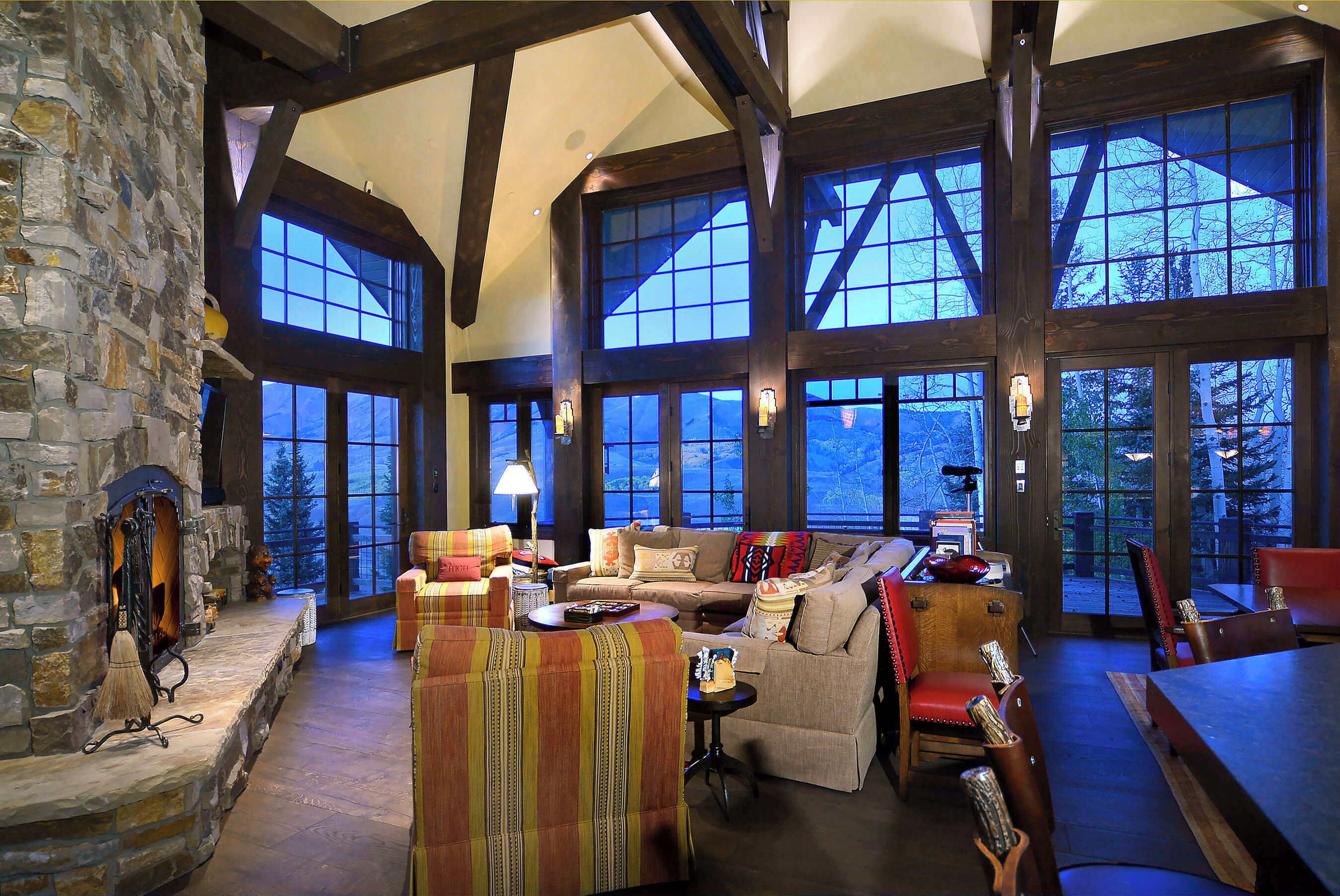 A spacious interior with a stone fireplace, large windows, and a cozy seating area.