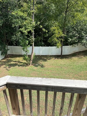 A wooden deck with a white fence in the background.