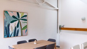 A modern meeting room with a wooden table, grey chairs, and a colorful abstract painting on the wall. - BOUTIQUE STAYS - Just My Type (Richmond)