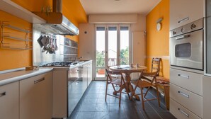 Uma cozinha compacta com fogão a gás, forno e área de jantar com mesa redonda e cadeiras.