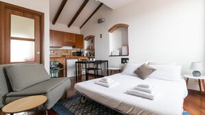 A hotel room with a bed, a sofa, a small table, a kitchen area, and a bathroom. - Italianway - Costiglioli 8 B (Sanremo)
