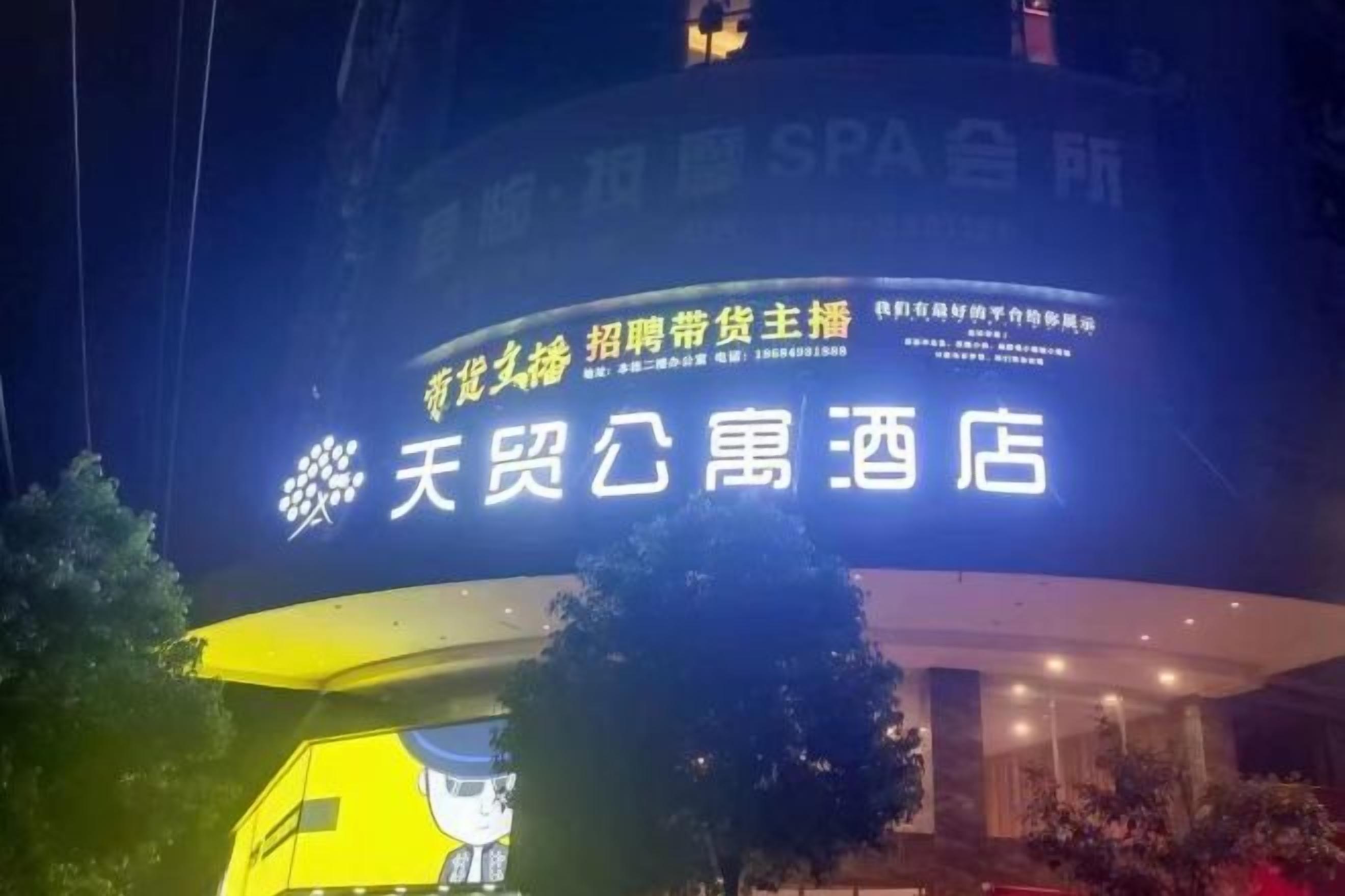 A hotel sign with Chinese characters and a logo.