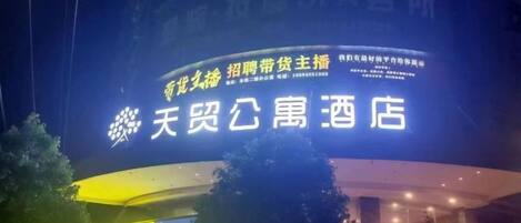 A hotel sign with Chinese characters and a logo.