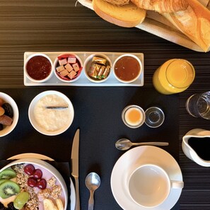 A breakfast table with various food items and drinks. - Hotel SPA Piscine le Petit Castel (Beuzeville)