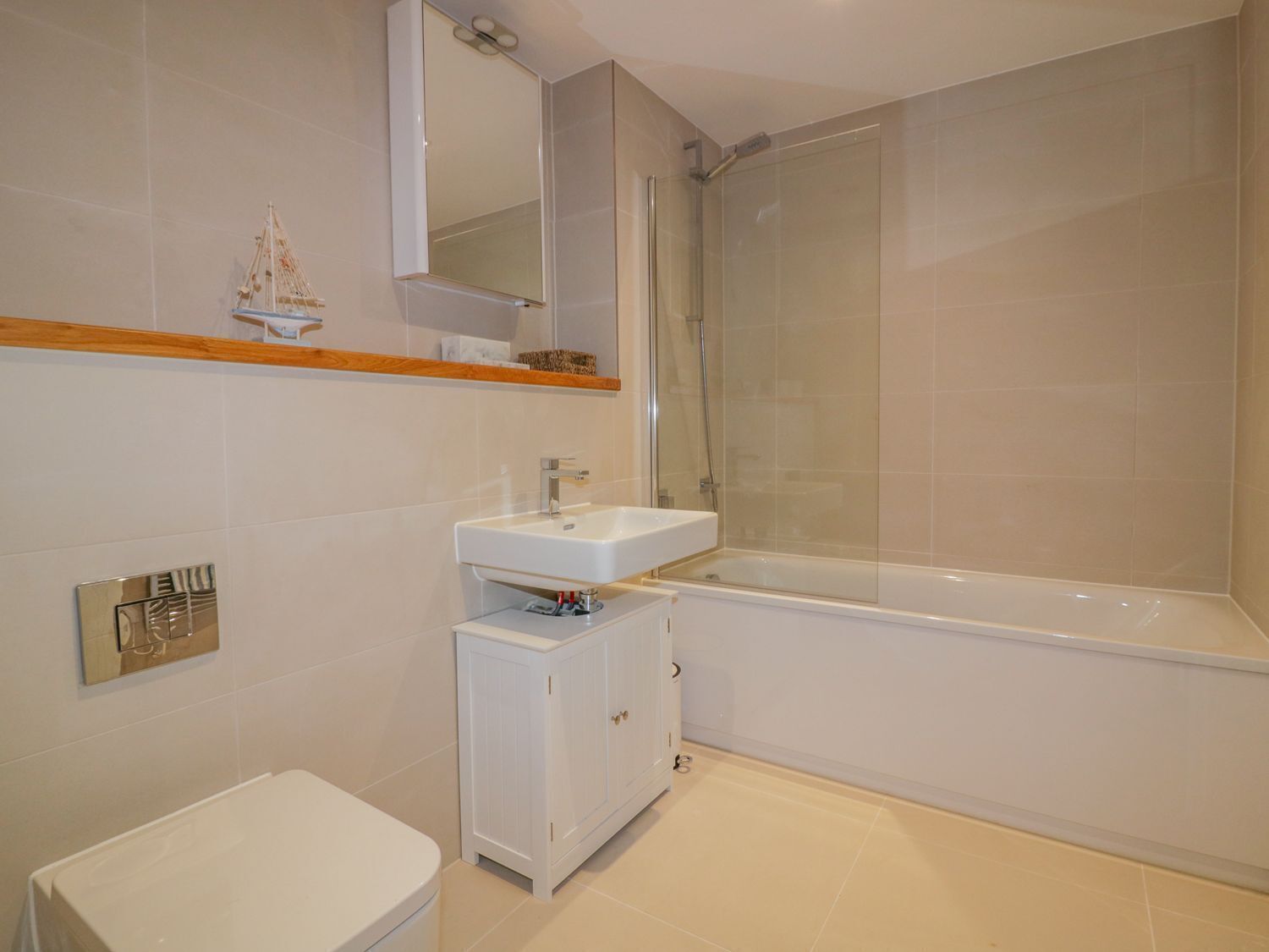 A modern bathroom with a white sink, a toilet, a shower enclosure, and a bathtub.