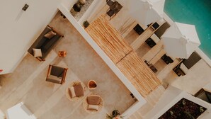 Una terraza en la azotea con piscina, sillones de descanso y zona de comedor.