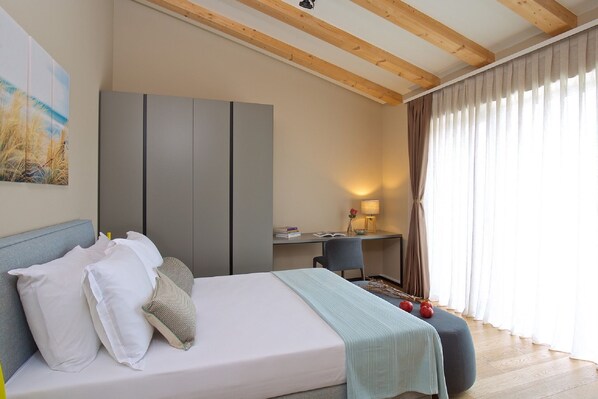 A bedroom with a bed, a desk, and a chair.