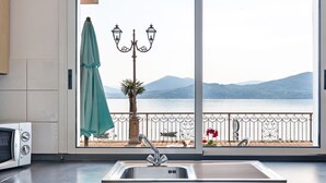 Une cuisine donnant sur un balcon, avec un évier et un four à micro-ondes.