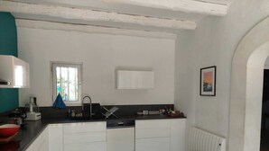 Una cocina moderna con armarios blancos, encimera negra y ventana que deja entrar luz natural.