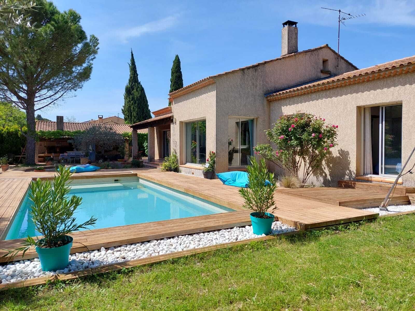 Uma casa com piscina, um pátio e um jardim.