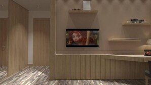 Una habitación moderna con pared de paneles de madera, televisor de pantalla plana montado y un escritorio con silla.