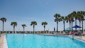 A swimming pool with lounge chairs and palm trees. - Beachfront 2Br, 2 Bath at Dunes of Panama- Sleeps 8  (3 pools, one heated) (Panama City Beach)