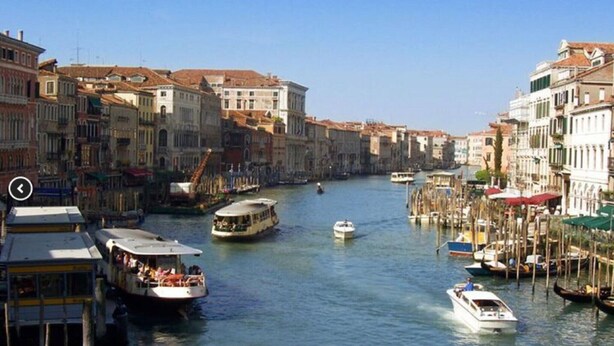 Un canal bordé de bateaux et d’immeubles.