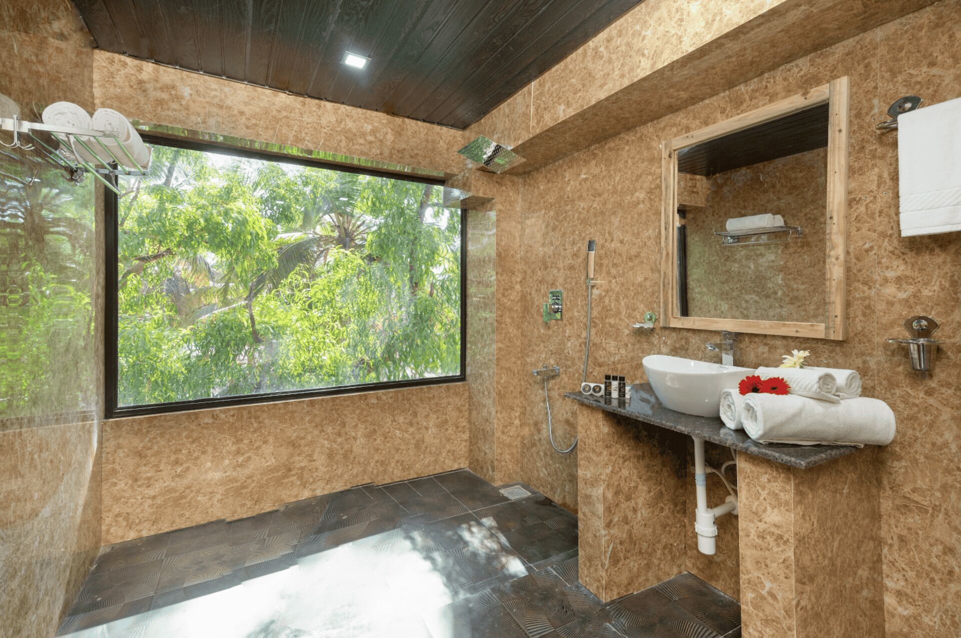 A bathroom with a large window, a sink with a mirror, and a shower area.