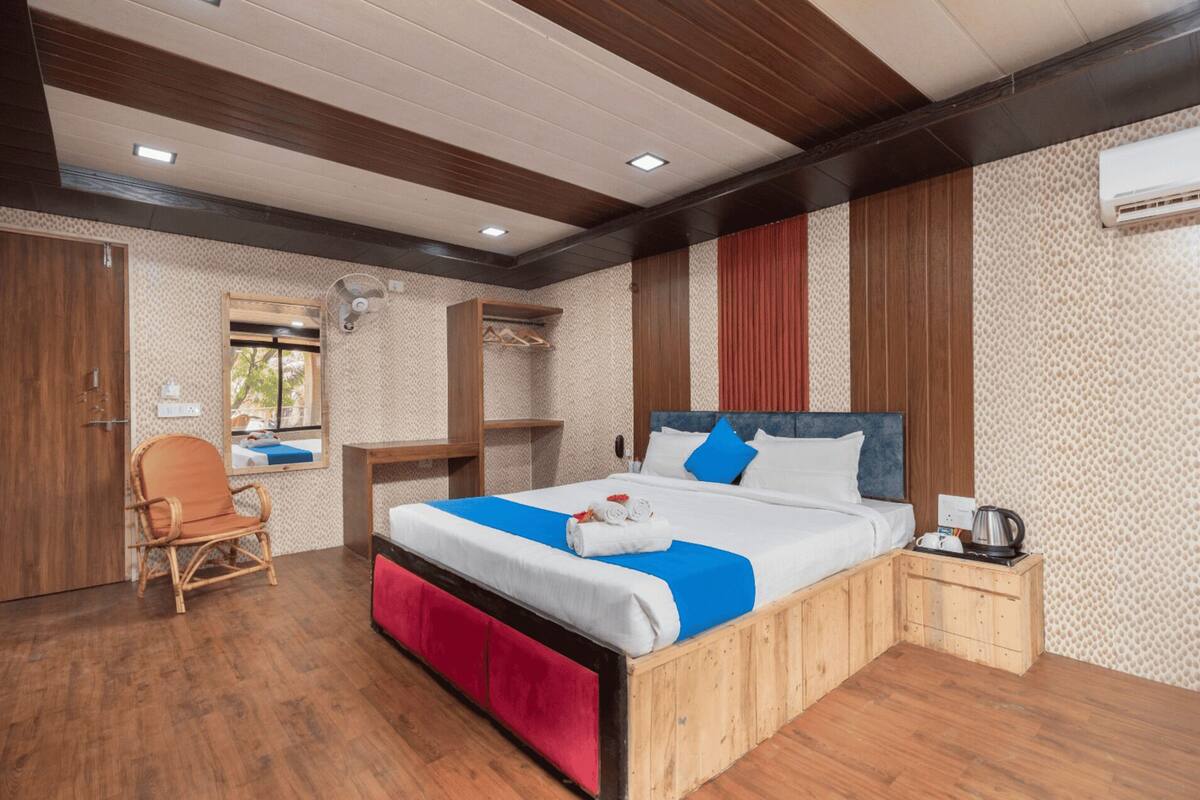 A bedroom with a wooden bed, a chair, a desk, and a window.